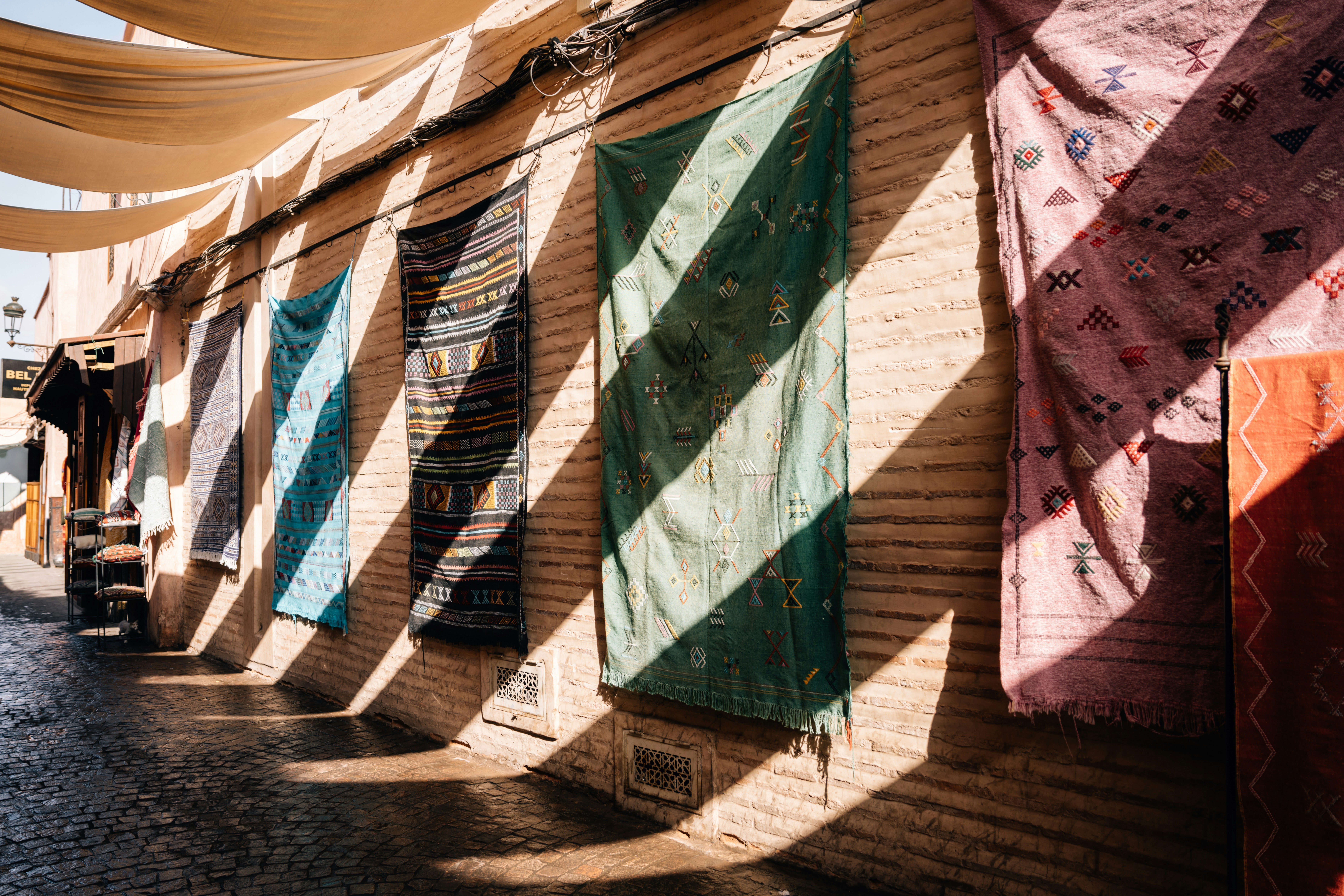 Rugs hanging on a medina wall in Marrakech, diagonal light